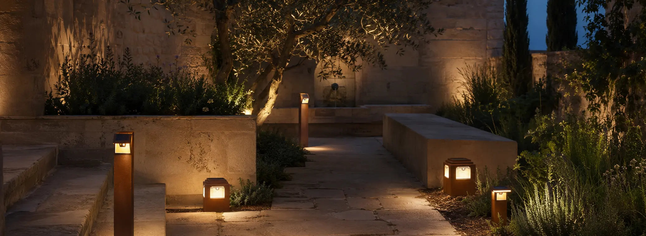 Jardín mediterráneo con luminarias solares de acero Corten al anochecer